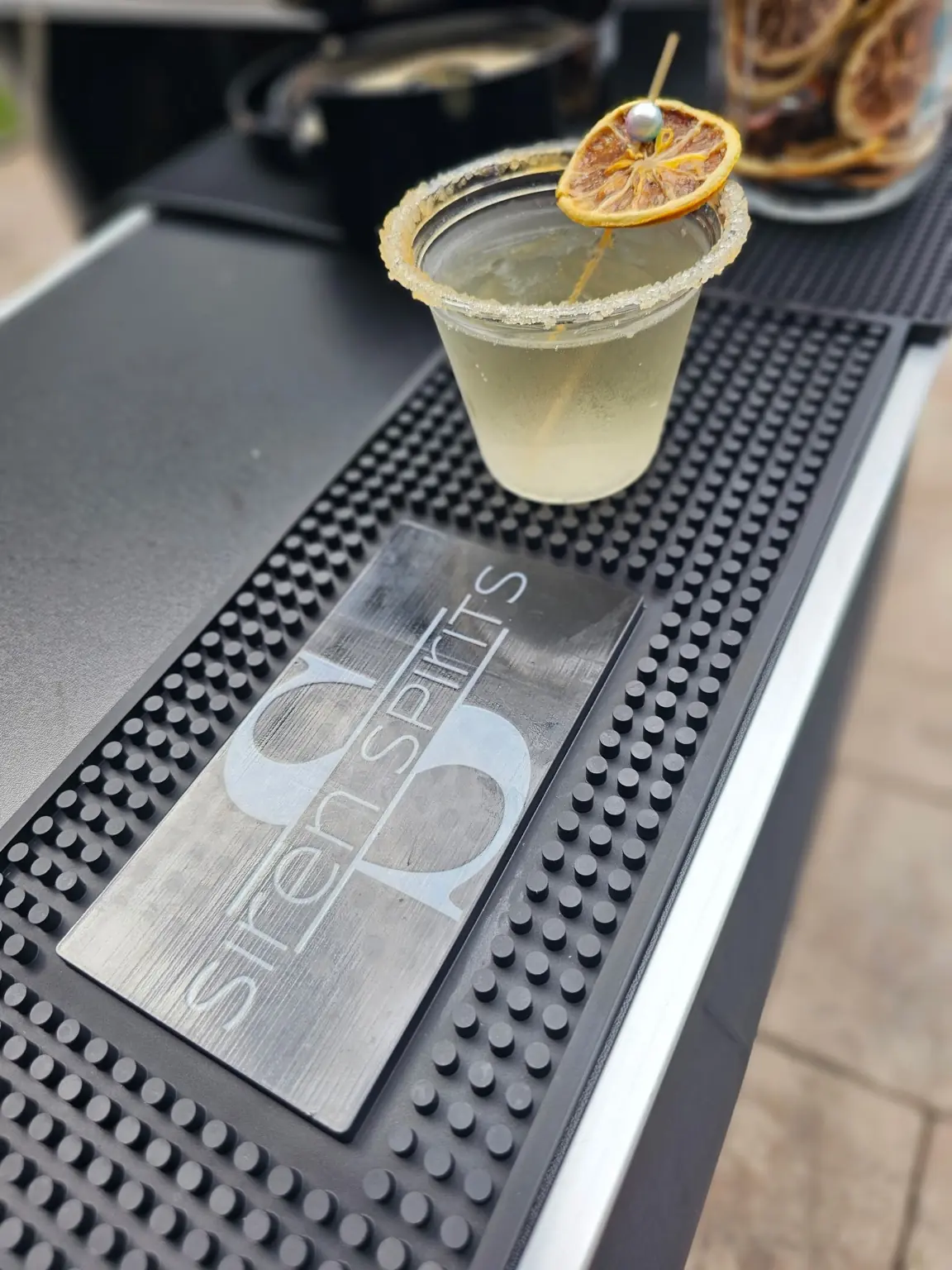 Closeup of a cocktail glass with Siren Spirits branding